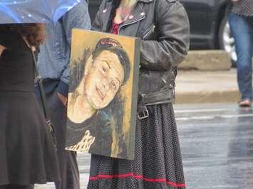 A painting of Adam Kargus is carried into the London courthouse by his sister, October 6, 2017. (Photo by Miranda Chant, Blackburn News)