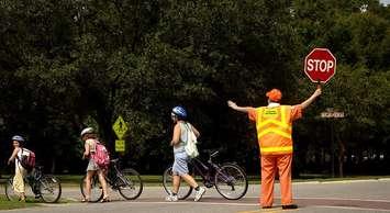 A crossing guard helps residents cross the street in Charleston, South Carolina. (Photo by U.S. Air Force photo/Airman 1st Class Nicholas Pilch)