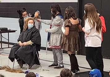 Kim George gets her hair cut at Hillside School at Kettle and Stony Point First Nation. October 29, 2021 Image captured via live video on Facebook.
