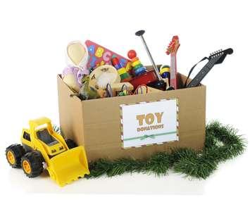 A large corrugated box with a "toy donations" sign filled with assorted toys and surrounded by Christmas garland and a toy bulldozer.© Can Stock Photo / McIninch