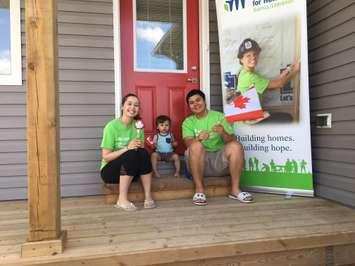 Rebecca Bain and Tyler Norland, with their son Kaden, celebrate after recieving the keys to their new home at 578 Scenic Dr. in Watford. July 14, 2017 (Photo by Sue Storr)
