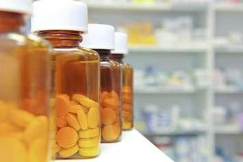 A row of pill bottles at a pharmacy. File photo courtesy of © Can Stock Photo / gemphotography.