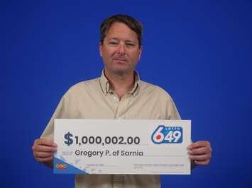 Gregory Potter of Sarnia picks up his LOTTO 6/49 win. Image courtesy of OLG.