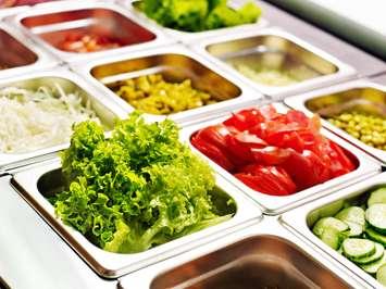 Tray with food on showcase at cafeteria. © Can Stock Photo / Geleol