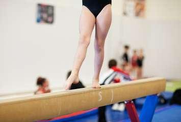 A gymnastics competitor on the balance beam. © Can Stock Photo / songbird839