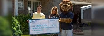 College President Judith Morris and Pounce present Adam Riggi with a cheque for free tuition. July 11, 2019. (Photo by Lambton College)