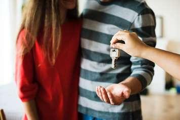 A couple receives keys to new home. Google image labeled for reuse.