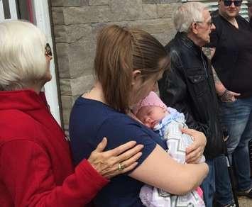 Mary Parkes comforts Kim MacIntosh, holding baby Paige, while her father Ralph MacIntosh talks about his wife Roberta. May 24, 2017 (Photo by Melanie Irwin)