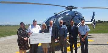 (From left to right) Melody Gibson, Donald Berrill, Cynthia Hansen, Bob Rooney, Paul Gingrich, Vern Yu and Ethan Saraiva honouring fallen pilot Dean Bass. July 24, 2019. (Photo by Enbridge)