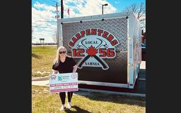 Big Brothers Big Sisters of Sarnia-Lambton Executive Director Kaylen Burgess showing a Spring Show and Sale sign. Submitted photo.