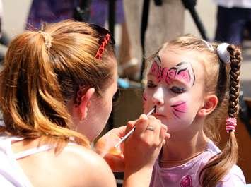 Artist paints butterfly on face of cute little girl. © Can Stock Photo / Mik122