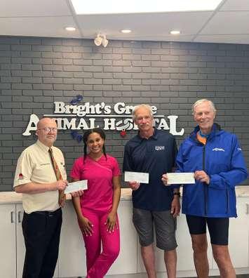Cheques presented to Dr. Melanie Moore to help with her efforts abroad. July 2022. (Photo courtesy of the Brights Grove Animal Hospital.)