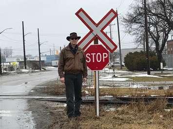 John Kinchsular stands by a new stop sign at Sarnia's St. Andrew St. rail crossing. February, 2018 (Photo submitted to BlackburnNews Sarnia)
