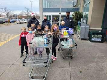 Sarnia Police and young members of the public taking part in the Cops for Cans event in support of The Inn of the Good Shepherd.  November 2021.  (Photo submitted by Sarnia Police)