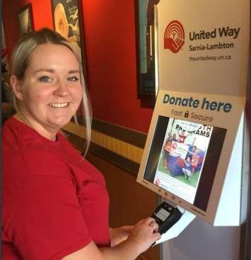 Hunter from the Coffee Lodge Canada at Finch and Wellington in Sarnia demonstrates how to use the United Way kiosk. Photo courtesy of Sarnia-Lambton United Way via. Facebook.
