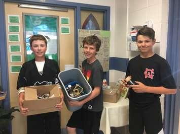 Mark Levesque, Brycen Boere and Reid King collect used batteries at Wyoming's Holy Rosary Catholic School. (Photo submitted by Principal Margaret DeGurse)