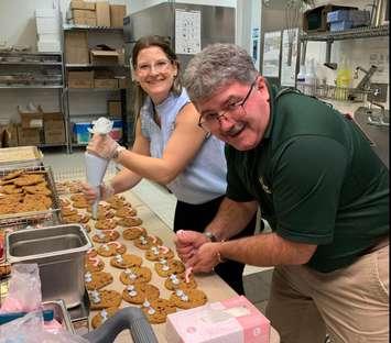 Inn of the Good Shepherd Executive Director Myles Vanni [front] helps make smile cookies during the 2023 campaign. Image courtesy of the Inn of the Good Shepherd Facebook page. 