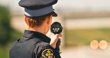 An Ontario Provincial Police officer with a radar speed gun. (Photo by OPP)